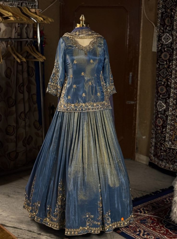 Luxury elegant bridal lehenga in deep blue with detailed gold embellishments and flowing skirt, representing timeless bridal couture design.